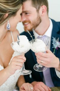 bride and groom toasting glasses with ice cream