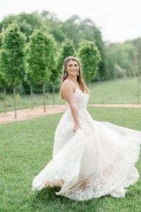 bride twirling dress on lawn