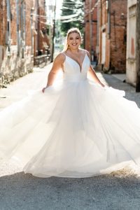 bride twirling dress in alley