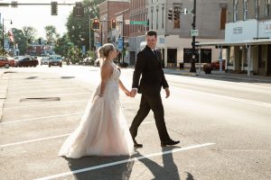 bride and groom walking across street
